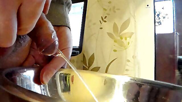 Closeup of John peeing into a steel bowl